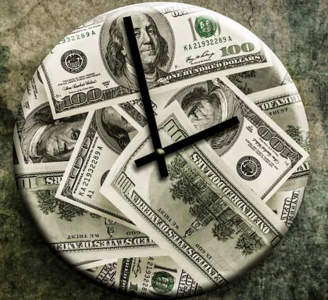 Clock with a background of dollar bills