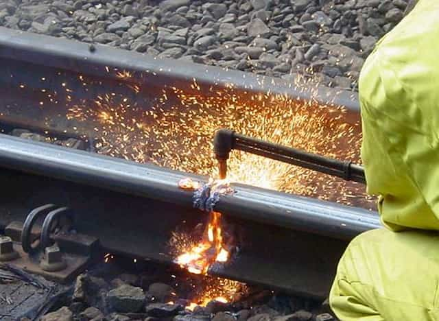 Man cutting a rail with a oxyfuel torch