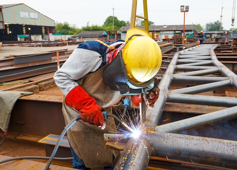 Fluc-cored arc welding process performed outdoors to weld steel structures